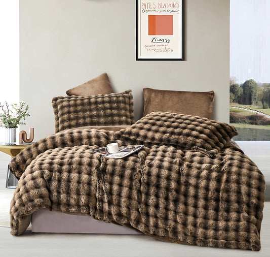 A brown quilted comforter set on a bed, with accompanying pillow shams, displayed in a bedroom setting.