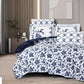 Navy and white floral patterned bedding set on a bed in a bedroom.