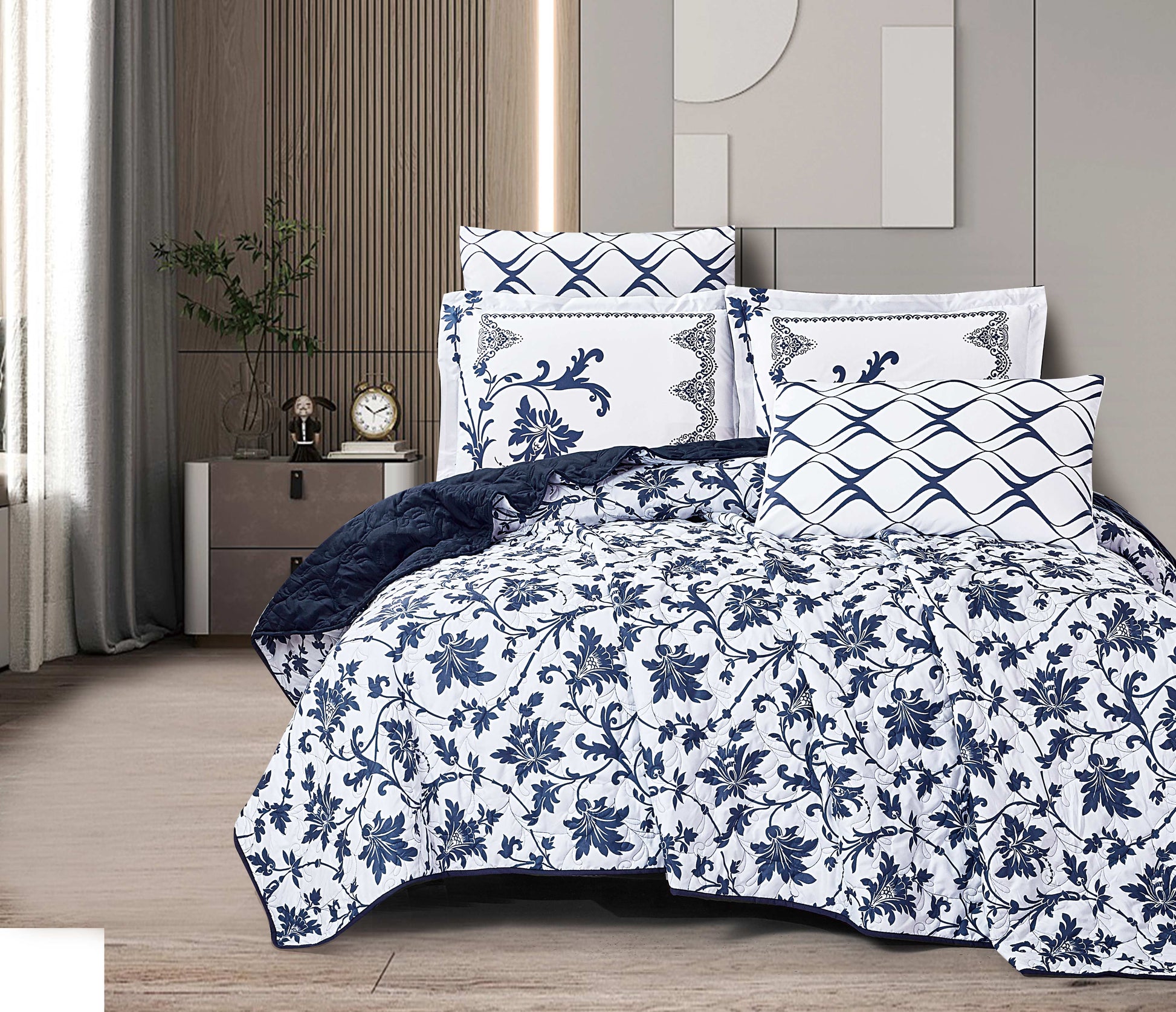 Navy and white floral patterned bedding set on a bed in a bedroom.