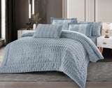 A quilted grid flannel comforter set in gray, displayed on a bed with matching pillows and bedsheet.