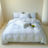 A duvet cover set with a striped pattern featuring a character design, displayed on a bed in a room with light decor.