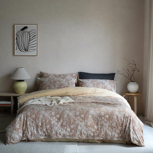 A luxury hotel cotton duvet cover set on a bed, with a floral design in beige and brown tones, displayed in a serene bedroom setting.