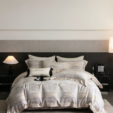 A printed bedding set on a bed, with a variety of pillowcases and a duvet cover in a geometric pattern, placed in a room with bedside tables and lamps.