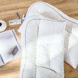 A white adjustable cervical support brace laid out on a wooden floor, with packaging and a measuring tape nearby.