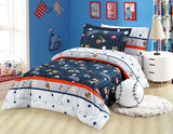 A quilted bedding set with a sports ball theme, displayed in a bedroom setting. The set includes a comforter, pillows, and bed sheets with a design that features various sports balls and a striped pattern.