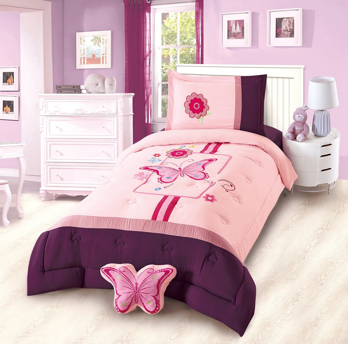 A pink bedding set with butterfly patterns displayed in a children's room setting.