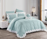 A blue lace-trimmed comforter set on a bed, with matching pillows and bedsheet, in a bedroom setting.