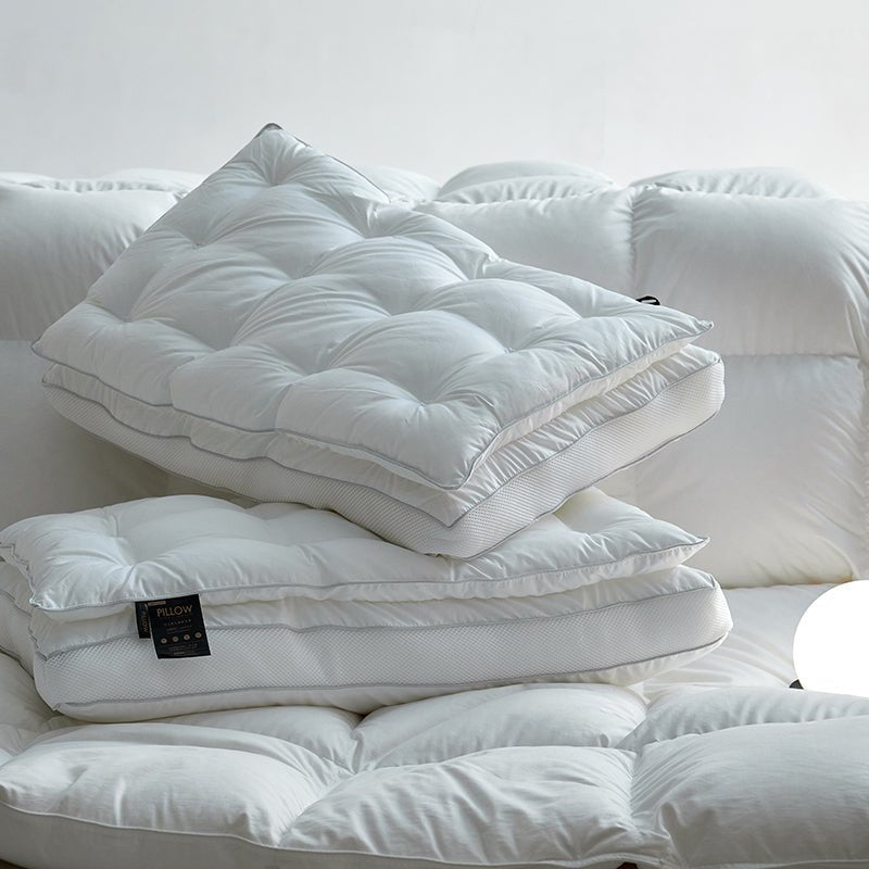 A white, down-filled pillow core displayed on a sofa, with a tag visible on one of the pillows.