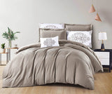 A bedding set in a mocha color with floral patterns on the pillows, displayed on a bed in a room with bedside tables and lamps.