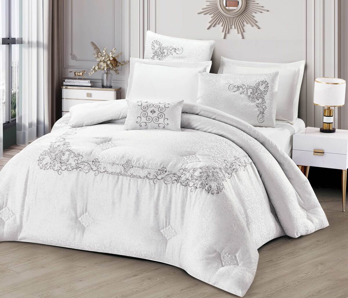 A white bedding set with lace trimmings, displayed on a bed in a room with elegant interior decor.
